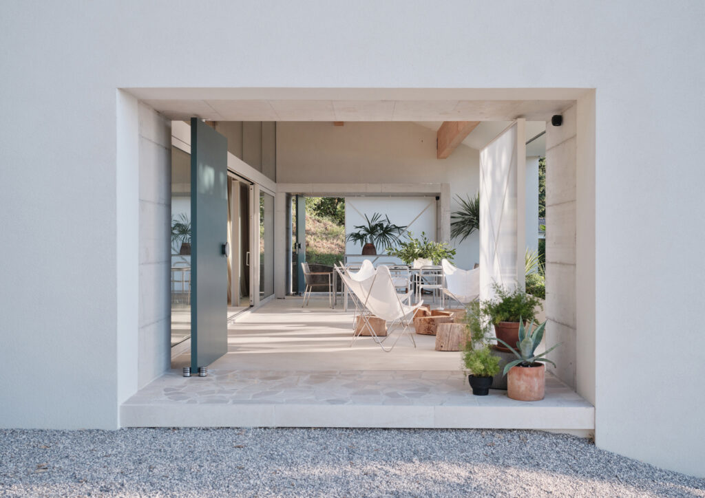 a white building with a patio and chairs